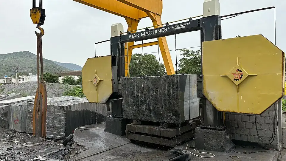 Block cutting machine sawing a granite block into slabs