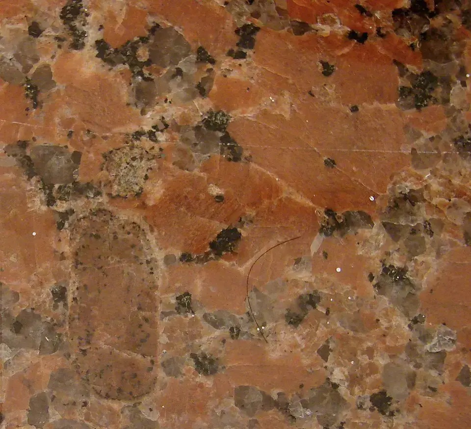 Red granite surface with dark mineral clusters