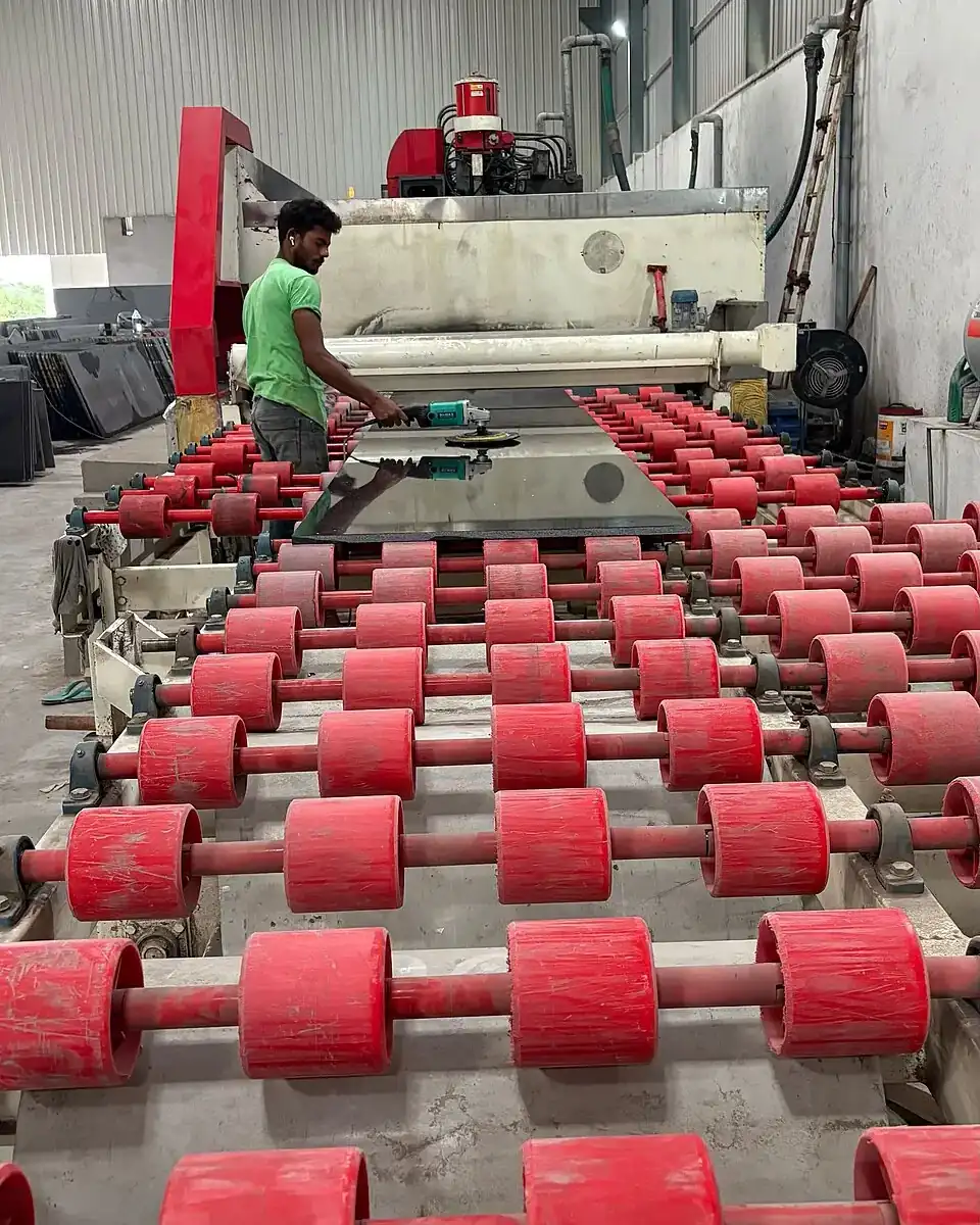 Worker operating a granite slab polishing line